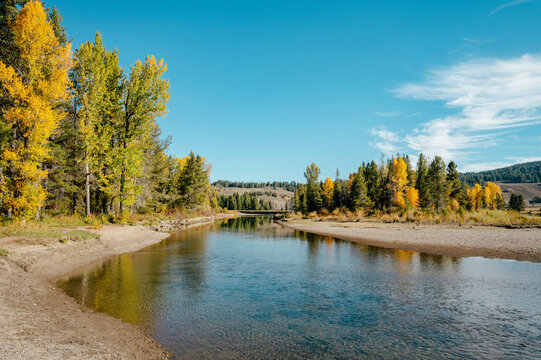 Low water reveals a broad exposed shoreline along a winding river.