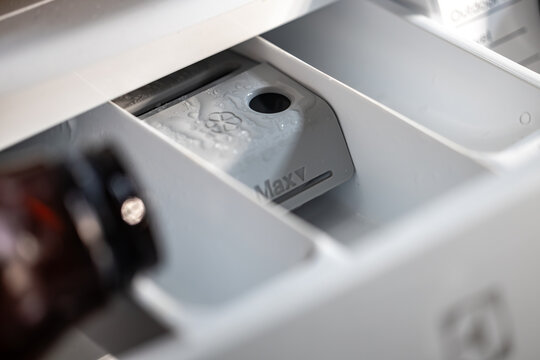 Stockholm, Sweden A hand pours laundry detergent into a washing machine drawer to wash clothes.