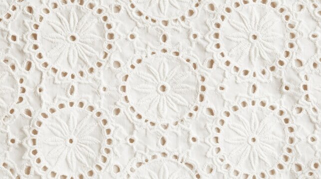 Close-up of delicate white eyelet fabric with intricate floral patterns. Perfect for summer clothing or craft projects.