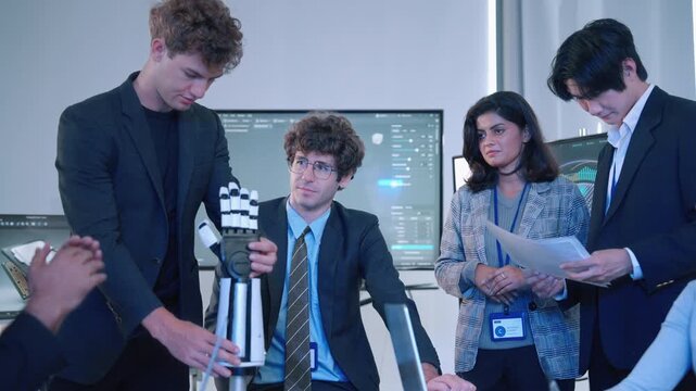 Multicultural engineering team discussing a robotic hand prototype and reviewing technical information during a collaborative technology meeting.
