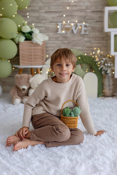 Cute boy, child in chic clothing on a decorated background in studio, enjoying