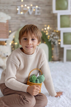 Cute boy, child in chic clothing on a decorated background in studio, enjoying