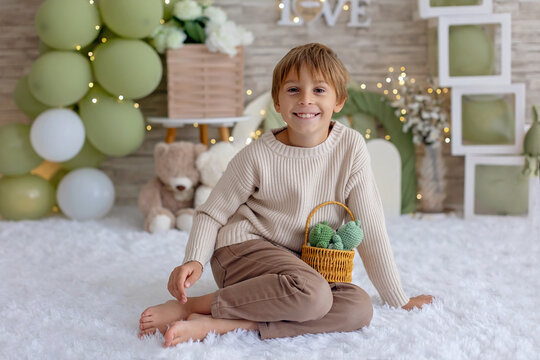 Cute boy, child in chic clothing on a decorated background in studio, enjoying