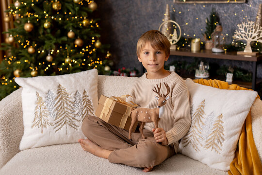 Happy child on Christmas, enjoying some quality time, opening presents, kids on Christmas eve in decorated home