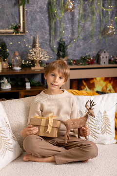 Happy child on Christmas, enjoying some quality time, opening presents, kids on Christmas eve in decorated home