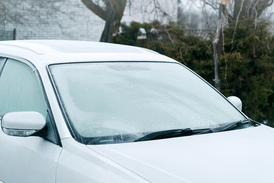 Snowy windshield covered in ice and frost
