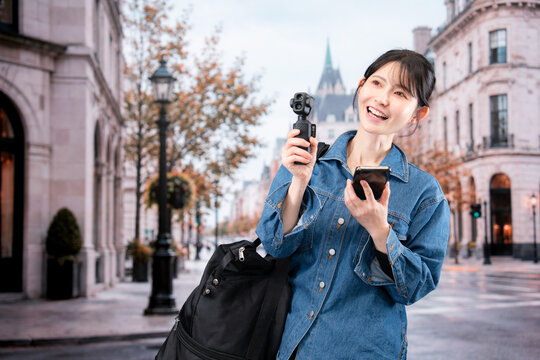 海外の街を歩きながら動画を撮影する女性