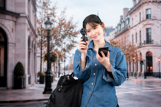 海外の街を歩きながら動画を撮影する女性