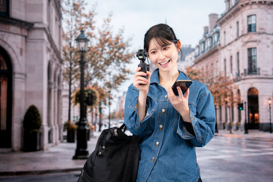 海外の街を歩きながら動画を撮影する女性