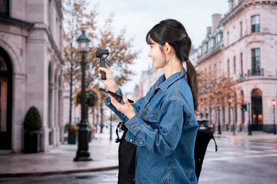 海外の街を歩きながら動画を撮影する女性