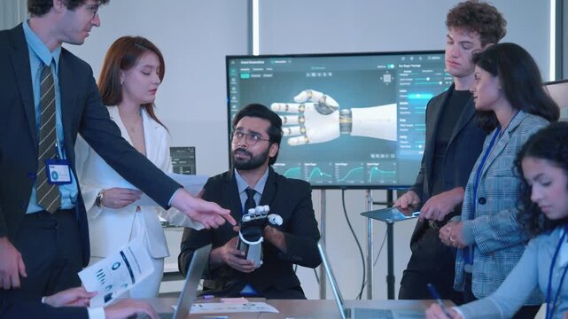 Engineering professionals discussing a robotic hand prototype, technical documents and digital design data during a collaborative technology project meeting.
