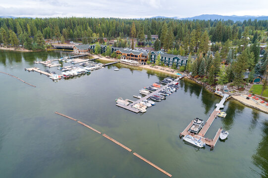 Peaceful lakeside resort with docks, boats, and forested mountains in background