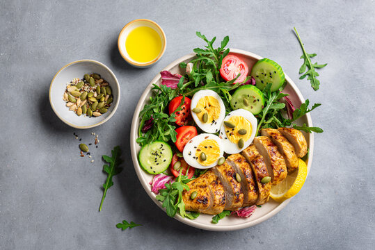 High protein lunch bowl with chicken, eggs and vegetable salad