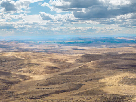 Wide desert with soft hills fading into hazy mountains