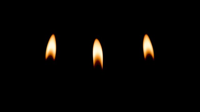 Breeze blowing out candle flame dark view closeup. Wax taper fire ending on black background. Night glowing dimly with flickering light. Smoke curling up slowly from wick. Peaceful atmosphere concept