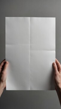 The image shows hands holding a crisp, folded white piece of paper, offering a blank canvas for a message, data, or creative ideas