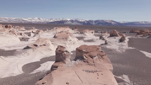 Eroded pumice ridges of Campo de Piedra P&oacute;mez stretch toward distant snowcapped Andes under a clear sky in a smooth drone flyover of this high Andean desert.
