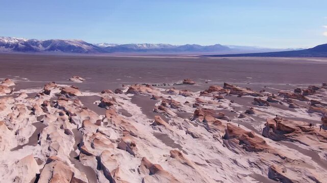 Campo de Piedra P&oacute;mez pumice formations stretch across a high Andean desert as a small 4x4 convoy crosses the plain in bright daytime light, suggesting remote adventure travel.