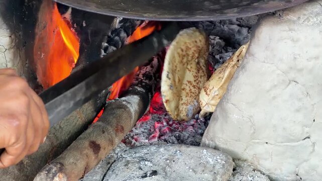 Making roti ya baking bread chapati on the mud stove or clay stove traditional food 4k footage