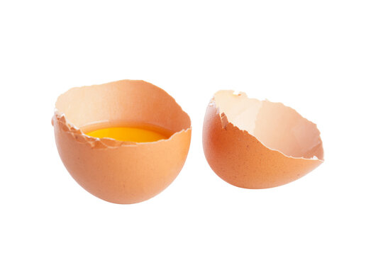 Cracked egg shells with yellow yolk inside on a plain white background