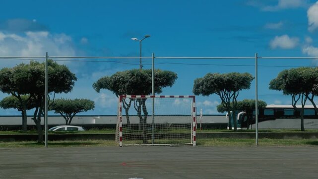 Empty street soccer goal with net on an outdoor futsal court under blue sky with clouds, S&atilde;o Miguel, Azores, Portugal