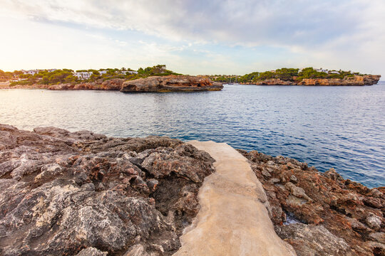 Rocky cove with seaside path in Cala d'Or, Mallorca, Spain.