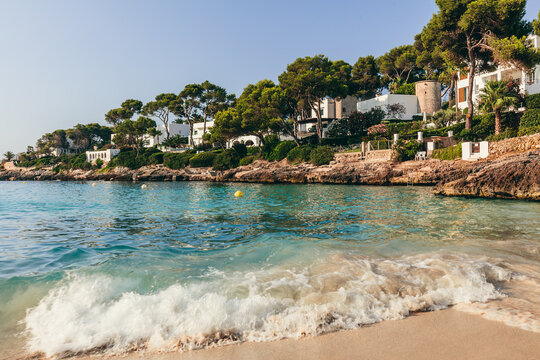 Cala Petita turquoise beach with waves in Cala d'Or, Mallorca, Spain.