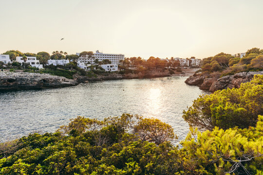 Sunset bay with coastal hotel in Cala d'Or, Mallorca, Spain.
