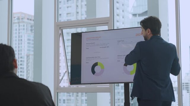 Business presentation with male speaker discussing financial data chart on screen, presenting report to colleague during focused office meeting and professional discussion with urban city view