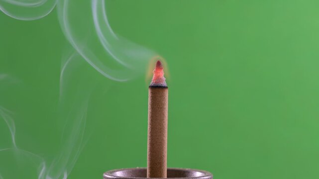 Occult Incense Stick smoldering, emitting wispy, ethereal white smoke tendrils on a bright green chroma key background, perfect for mystical