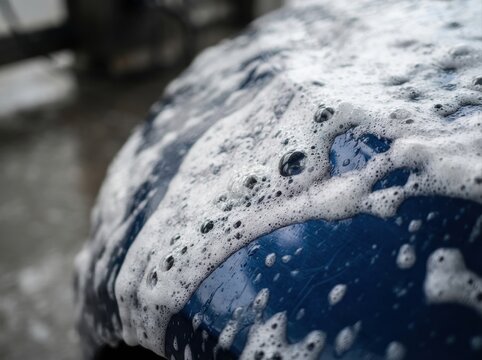 snow foam car detailing macro Car covered with soap suds during a wash process.