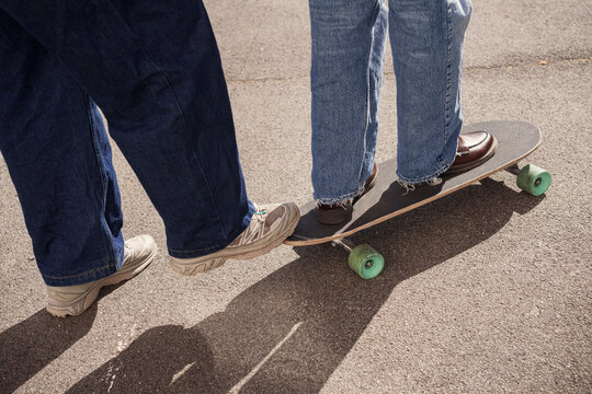 A man and a woman try skateboard training on the street