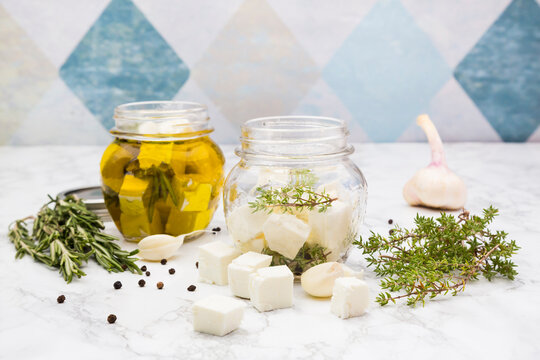 Glass of diced sheep cheese pickled in olive oil, thyme, garlic, pepper and rosmary