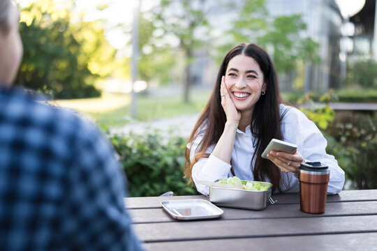 Businesswoman enjoys a lunch break conversation with a male colleague