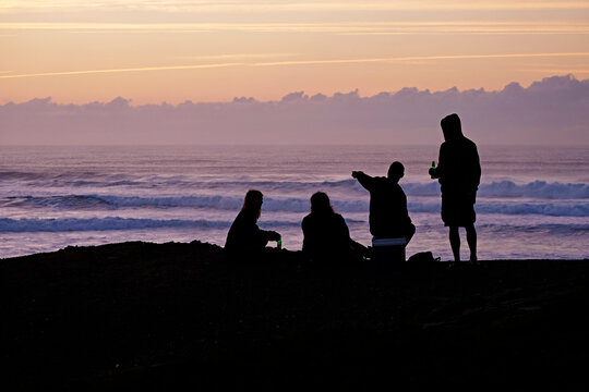 Portugal, Algarve, Sagres, Cordoama Beach, silhouette of four people at dusk