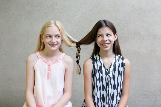 Portrait of two long-haired girls with one braid