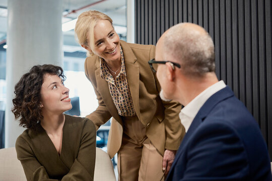 Smiling businesswoman introduces colleague in an office