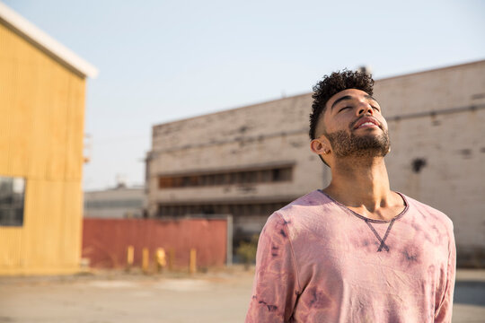 Young man outdoors leaning back