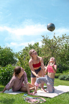 Family plays with a medicine ball during outdoor fitness workout
