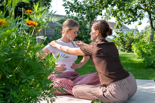 Woman guiding another woman in somatic therapy outdoors