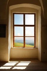 Abandoned stone interior with sunlight through window creating natural light and shadow in empty architectural space © Konstiantyn