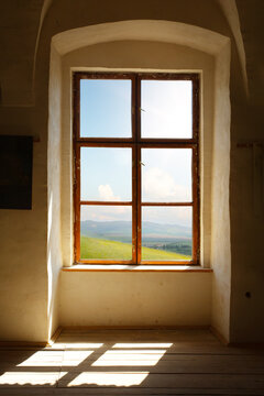 Abandoned stone interior with sunlight through window creating natural light and shadow in empty architectural space