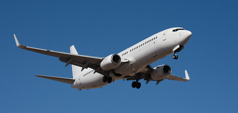 The plane lands, passenger airliner. The plane lands. Airplane, passengers flying in the blue sky, preparing to land at the airport