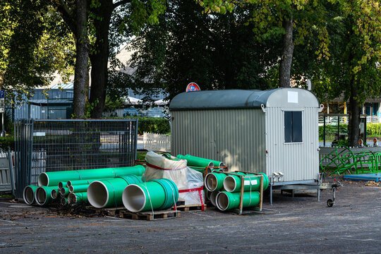 A trailer beside green pipes in a construction area
