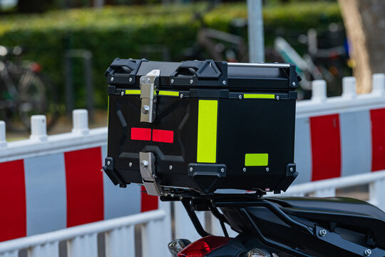 Delivery box placed on the motorcycle parked near barrier