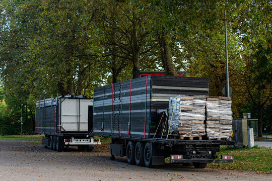 Two trucks parked with loads of wood in a green area