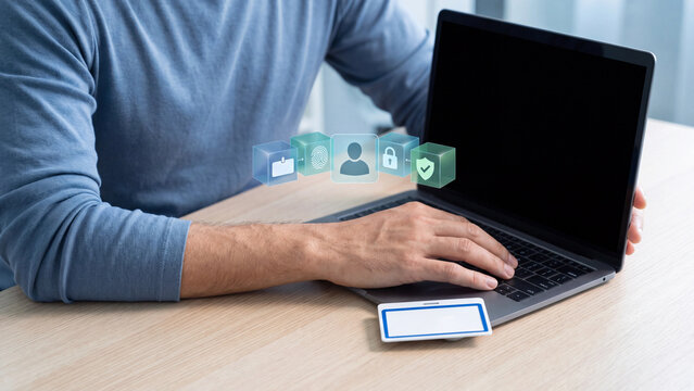 Identity and Access Management Concept, Employee Using Laptop with Blank ID Badge and Virtual Cubes Showing Fingerprint, User Profile, Padlock and Shield for Multi Factor Authentication