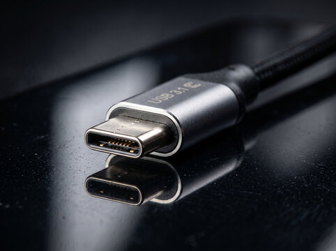Detailed close up of new usb 3.1 type c connector on reflective black surface.