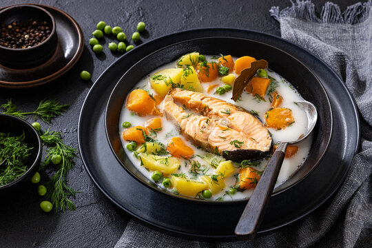 A large steak of cooked salmon in creamy soup