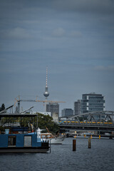 Berlin Skyline with Television Tower, Spree River, and Bridge Under Cloudy Sky. © Martin
